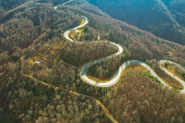 蜿蜒的山路在树木繁茂的地区。生态方法图片下载
