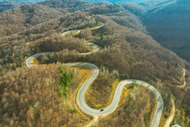 蜿蜒的山路在树木繁茂的地区。生态方法图片下载