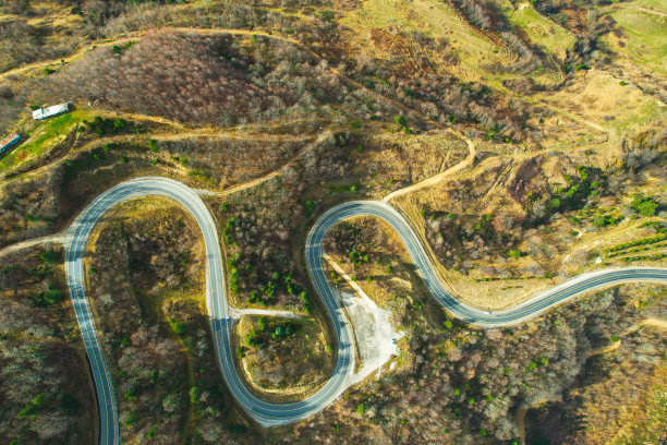 蜿蜒的山路在树木繁茂的地区。生态方法图片下载