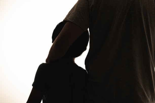 父亲和儿子肩并肩的剪影图片下载