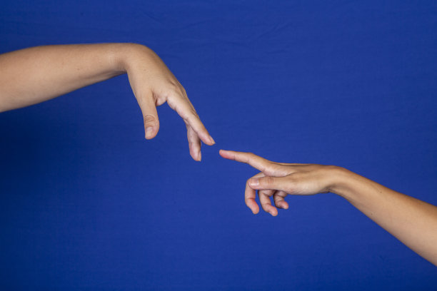 在蓝色背景上，手和手指相互接触图片下载