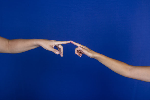 在蓝色背景上，手和手指相互接触图片下载