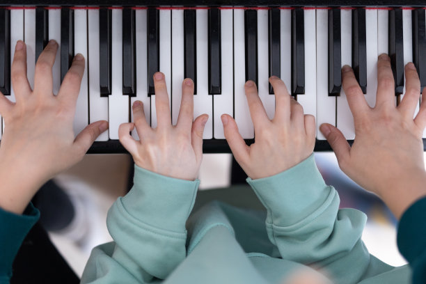 儿子和母亲一起弹钢琴图片下载