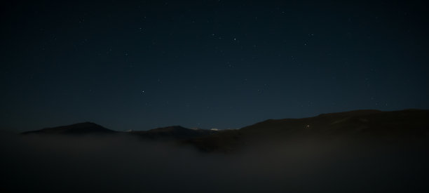 夜间景观在山间有低云和多岩石的山峰和星空，温暖的秋天黑暗的夜晚图片下载