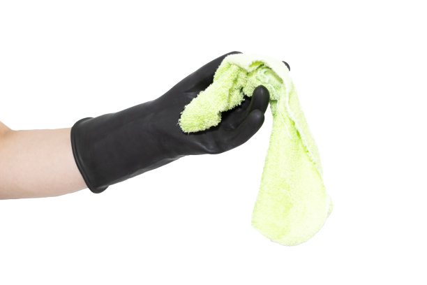 一只戴着黑色橡胶手套的手在白色背景上拿着一块清洁布。清洁工的手。图片下载
