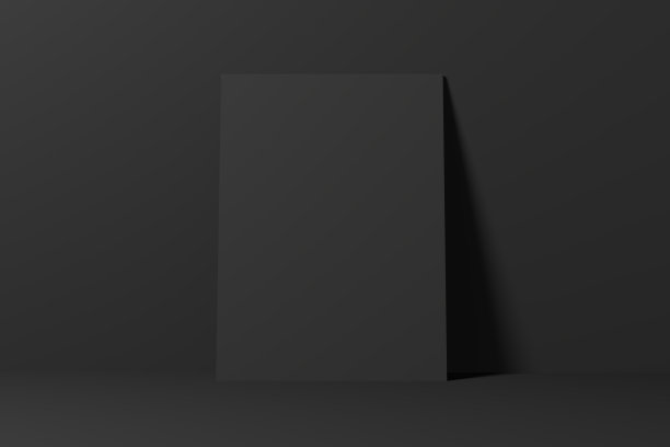 空白的黑色海报靠在黑色的墙上。图片下载