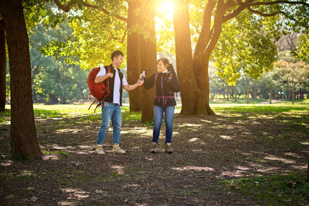 青年男女在森林里徒步和传递水瓶图片下载