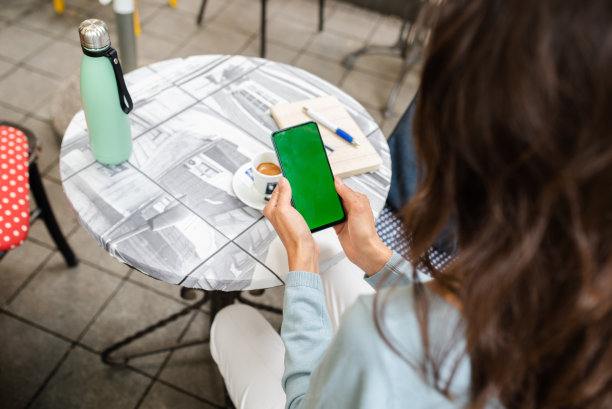 一名女子在咖啡馆使用智能手机图片下载