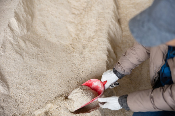 一名妇女在动物饲料仓库用勺子收集玉米粉图片下载
