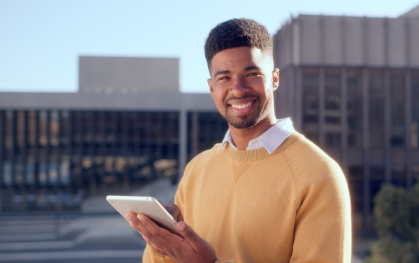 白天，在城市街道上，一个快乐、害羞、开朗的休闲男孩在户外摆姿势或看着手持相机。一个年轻，时尚的家伙在一个时髦，酷的城市位置的脸肖像-库存照片图片下载