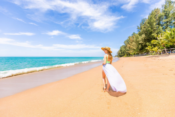 快乐的旅行者女人在泳装享受她的热带海滩度假图片下载