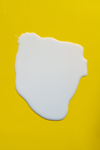 牛奶洒在黄色背景上图片下载