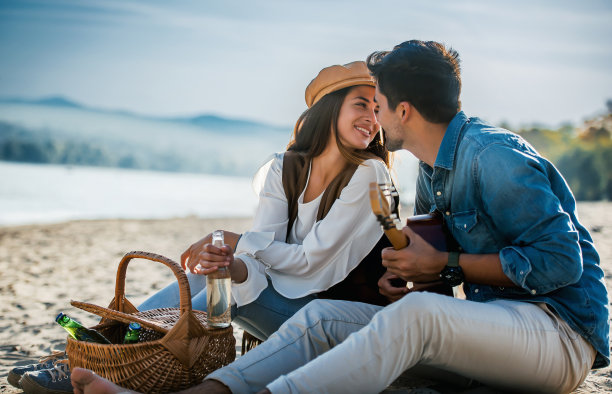 野餐。年轻夫妇在海滩上玩得很开心。生活方式，爱情，约会，度假概念图片下载