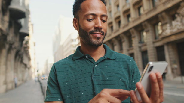 一个年轻人站在路边用手机的特写镜头图片下载