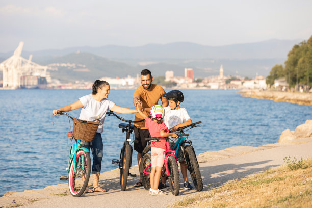 一家人与自行车站在海边击掌图片下载