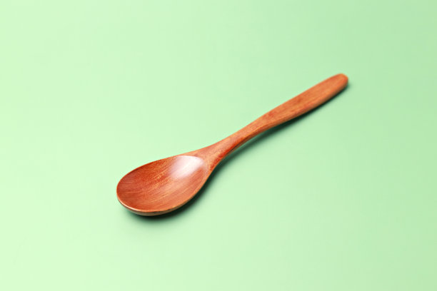 木勺孤立在绿色背景上图片下载