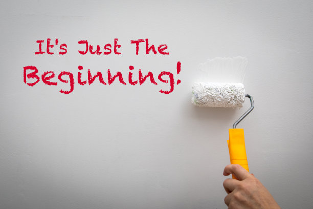 这只是个开始。用油漆辊涂一堵白色的墙图片下载