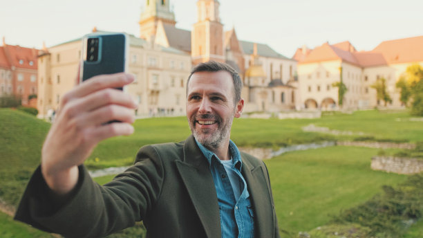 一名男子在旧城背景下用手机自拍图片下载