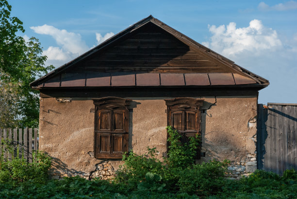 一座古老的石头房子，窗户上有木制百叶窗。图片下载