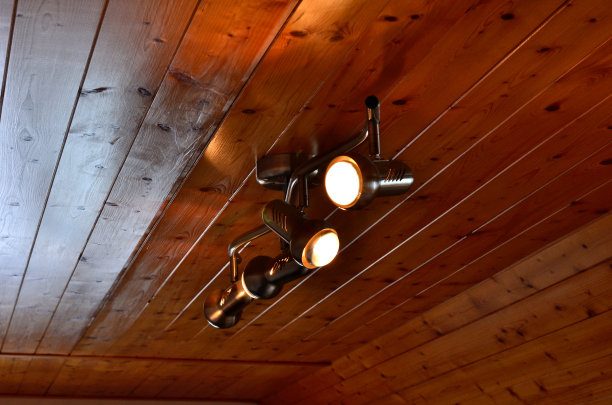 棕色天窗遮光百叶窗。窗户半开着，窗帘拉下，白天变成了黑夜。黑色纤维或铝编织其中。天花板和衬里的木制镶板图片下载