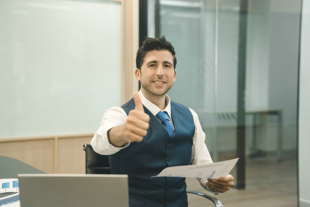 成功快乐的商人竖起大拇指。图片下载