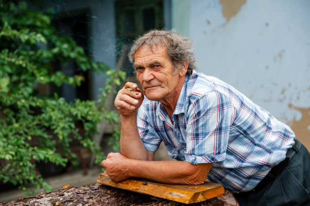 非常老的高级男子的肖像。悲伤的老人抽着烟。图片下载