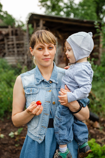 妈妈和儿子在吃零食。母亲给儿子草莓图片下载