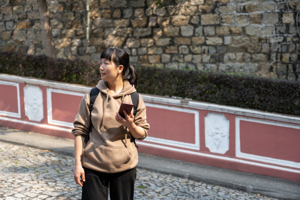 一位亚洲女游客在街上看手机图片下载