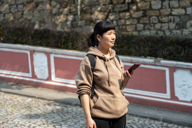 一位亚洲女游客在街上看手机图片下载
