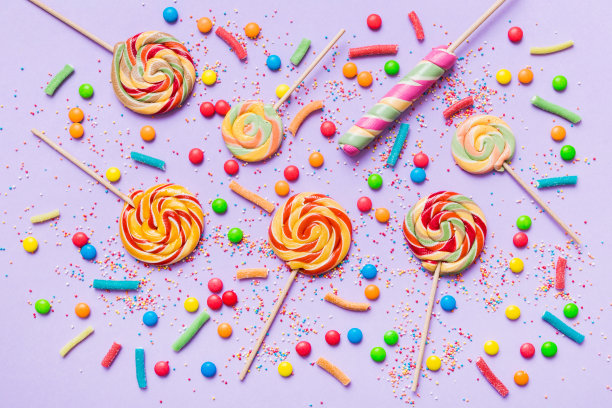 美味开胃的派对配件生日快乐，甜蜜。不同类型的糖果彩色背景，复制空间。多彩的生日派对背景图片下载