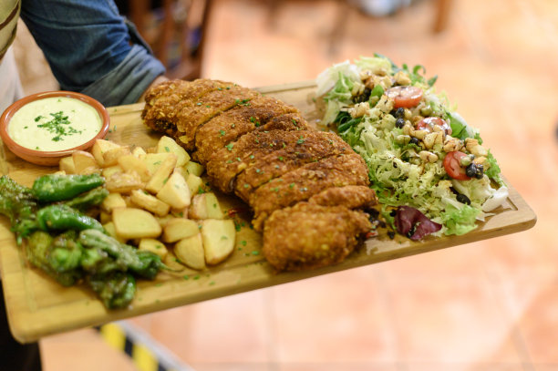 服务员端着一盘炒肉和蔬菜图片下载