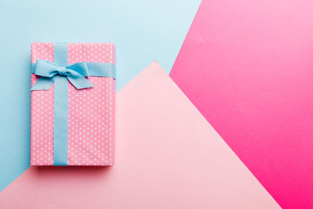 假日手工纸礼物系蓝丝带蝴蝶结顶部视图与复制空间。平铺假日背景。生日或圣诞礼物。圣诞礼盒概念与复制空间图片下载