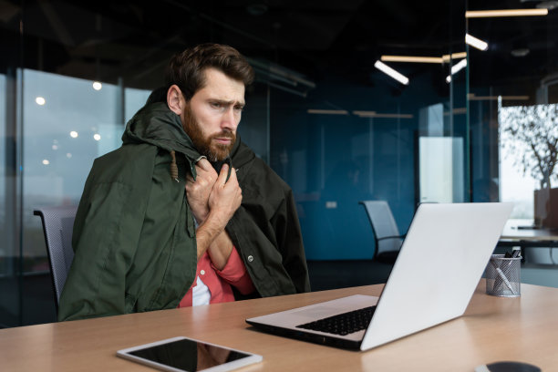 上班族在工作，没有暖气和坏了的办公室暖气，商人在用笔记本电脑工作，我会穿上外套图片下载