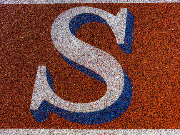 近距离的字母S在新的红色跑道与白色车道线和其他标记。图片下载