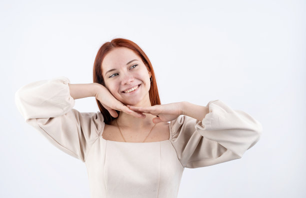 一个年轻美丽的女人触摸她的脸在白色背景的肖像，复制空间图片下载