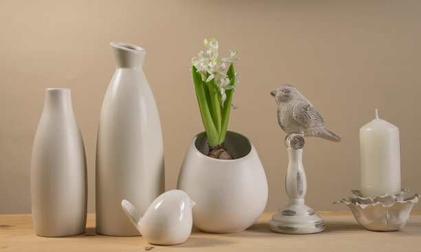 春季斯堪的纳维亚舒适的家居装饰:白色花瓶，白色风信子和鸟雕像图片下载