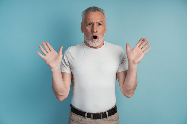一个惊讶和震惊的高级男子的肖像。人孤立在蓝色背景，复制空间，文字的地方。图片下载