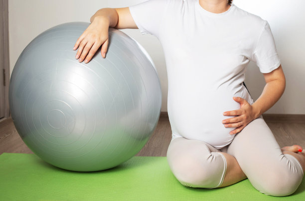 一个怀孕的女孩在怀孕的第三个月参加运动。健身和普拉提。妇女的健康。灰球健身球。图片下载