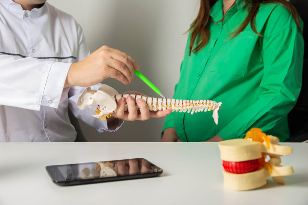 一个怀孕的女孩在神经科医生的预约，她的背部疼痛和肌肉紧张。怀孕期间慢性疾病加重。椎间疝和骨软骨病，脊柱突出。图片下载