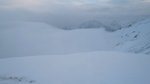 神秘的黎明伴随着雪山上的云图片下载