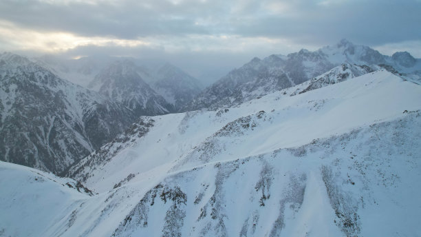 神秘的黎明伴随着雪山上的云图片下载