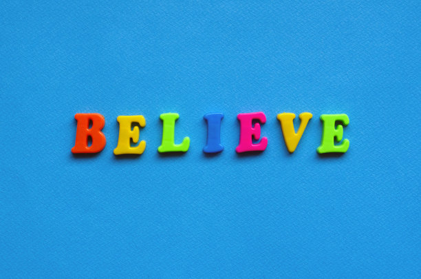 文字相信来自蓝色纸背景上的塑料彩色字母图片下载