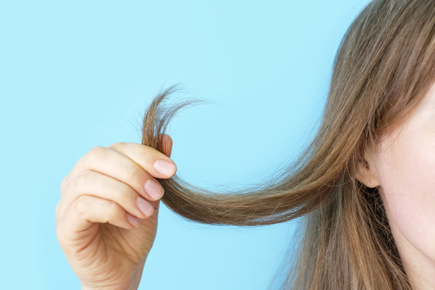 女孩抱着她的头发与分裂结束特写在蓝色背景。图片下载
