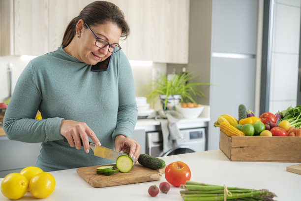 女人把手机放在耳朵和肩膀之间，一边做饭一边说话图片下载