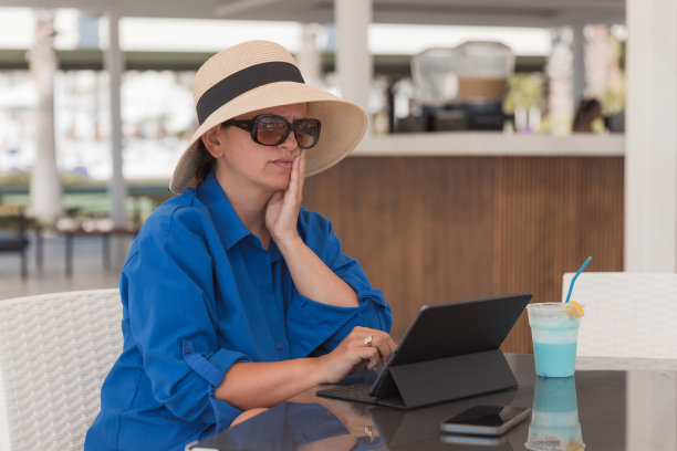 担心的女人在暑假期间使用平板电脑图片下载