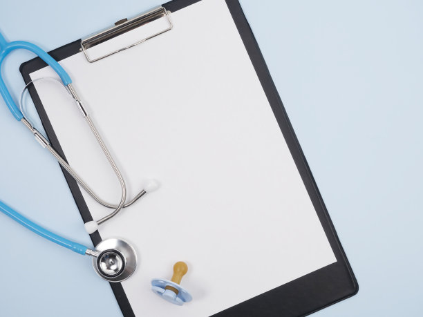 蓝色背景上有假人和平板的听诊器。帮助和治疗儿童的理念。图片下载