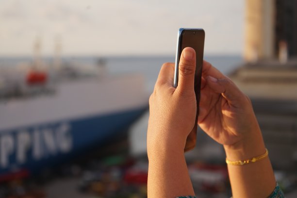 女性手持手机上网拍照图片下载