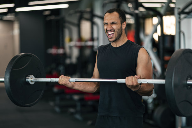黑人运动员在健身房努力举起杠铃时尖叫图片下载