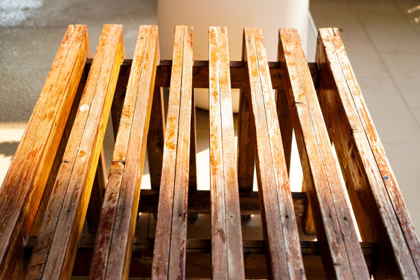 这张照片展示了早晨躺在泳池边的木条椅上的倒影。图片下载