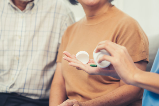 一位年长的妇女在护士的指导下，心满意足地和丈夫坐在一起。图片下载